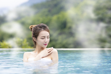 Fototapeta premium Young woman relaxing in hot springs