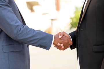Mature African American casually dressed businessman shaking hands.