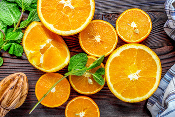 orange juice with mint squeezing on wooden kitchen background to