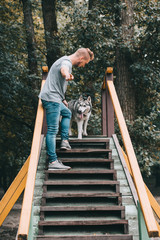 dog trainer with obedient husky dog on stairs obstacle
