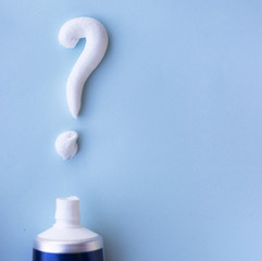 Question mark from toothpaste on blue background, toothpaste selection concept