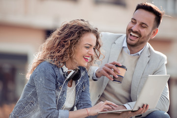 Loving couple using laptop on the street