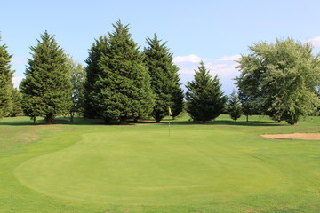 Fairway view of golf green with bunker to side