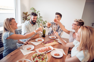 Smiling friends toasting with wine