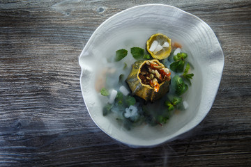 top view on dessert served in pumpkin decorated with mint and smoke