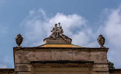 Fototapeta na wymiar Barcelona, Spain - May 10, 2018: Sculpture representing Art and Nature on the top of pavilion of Carlos IV in Labirinth Park of Horta. The words are 'Harmony of art and nature engenders beauty'.