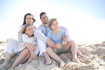 Family sitting on the beach in late afternoon