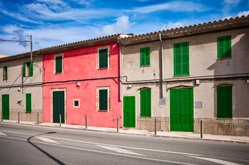 Street in Alcudia with old building facades and green shutters, Mallorca, Spain.