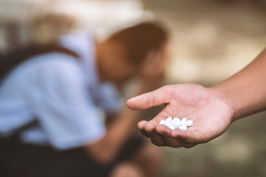 Hand Holding Pills With Student Is Headache In Background.