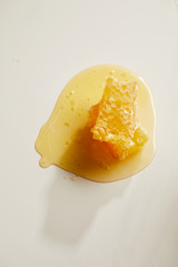 top view of sweet beeswax and honey on white surface
