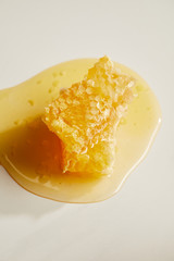 close up view of sweet beeswax and honey on white tabletop