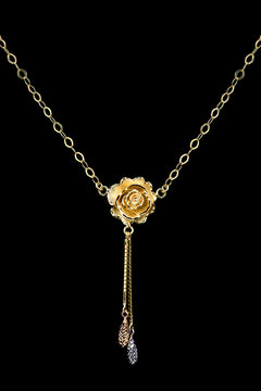Modern golden necklace on a dark pattern