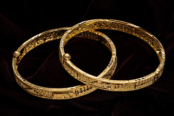 Golden bracelet on a dark pattern