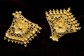 Golden earrings on a dark pattern