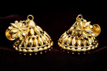 Golden earrings on a dark pattern