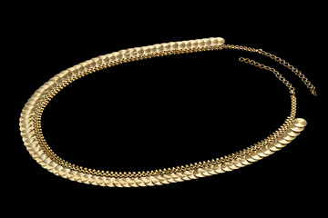 Golden paendant on a dark pattern