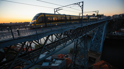 View of the Luis I Iron bridge with train over the Douro river at dusk, Porto, Portugal.