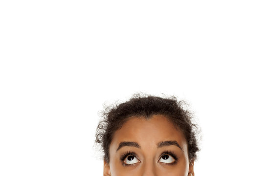 half portrait of a young dark skinned girl looking up on white background