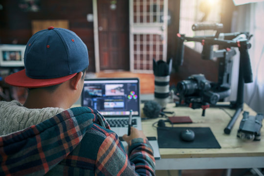 Young freelancer man editing video on laptop for uploading video to internet online or social media.