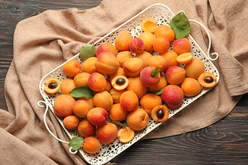 Tray with ripe sweet apricots on table