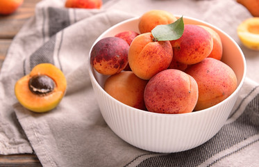 Bowl with sweet ripe apricots on table