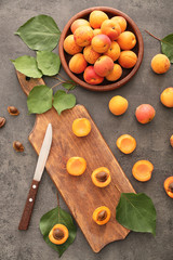 Cutting board and plate with ripe sweet apricots on table