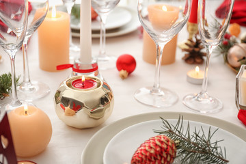 Stylish table setting with burning candles and Christmas decorations