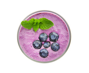 Glass of tasty blueberry smoothie on white background, top view