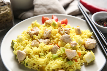 Delicious rice with meat and vegetables on plate, closeup