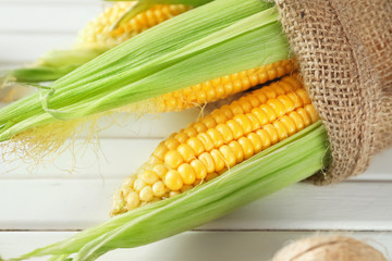 Ripe corn cobs on wooden background, closeup