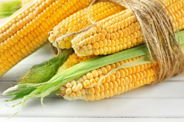 Ripe corn cobs on wooden background, closeup