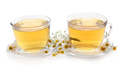 Glass cups of delicious camomile tea on white background