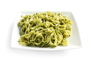 Plate of delicious pasta with pesto sauce on white background