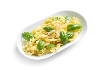 Plate of delicious pasta with basil on white background