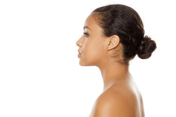 profile of young beautiful dark-skinned woman with bun on a white background