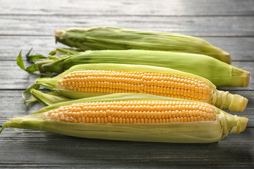Fresh corn cobs on wooden table