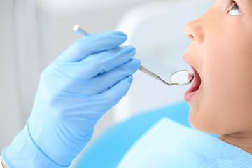 Fototapeta premium Dentist examining little boy's teeth in clinic, closeup