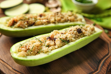Quinoa stuffed zucchini boats on board, closeup