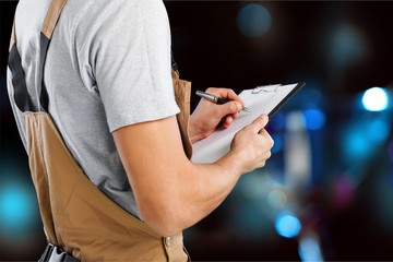 Worker of brewery taking notes at warehouse