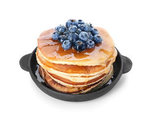 Frying pan with tasty pancakes and blueberries on white background