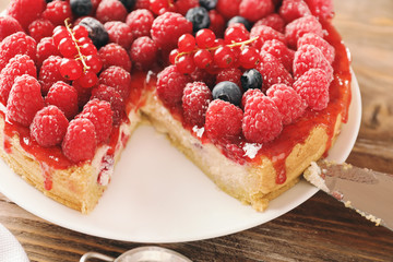 Delicious cheesecake with berries on plate, closeup