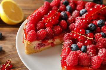 Delicious cheesecake with berries on plate, closeup
