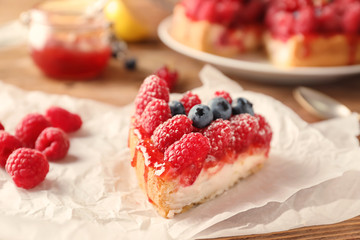 Piece of delicious raspberry cheesecake on table