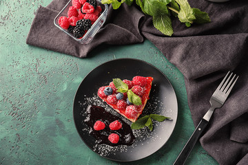 Plate with piece of delicious raspberry cheesecake on table