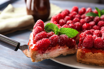 Delicious cheesecake with berries and piece on shovel, closeup