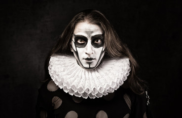 Portrait of man in goth style clothes and  ruff collar with scull makeup.