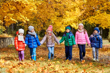 Happy children play in the autumn in a park.