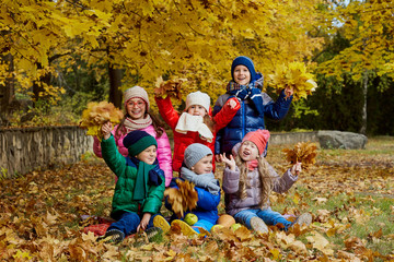 Happy children play in the autumn in a park.