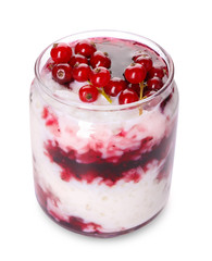 Glass jar with delicious rice pudding and currants on white background