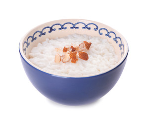 Bowl with delicious rice pudding and nuts on white background